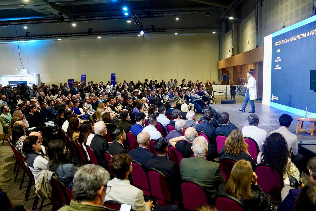Gastón Lentini con guardapolvo blanco exponiendo sobre proyectos de inversión en Argentina en Expo EFI